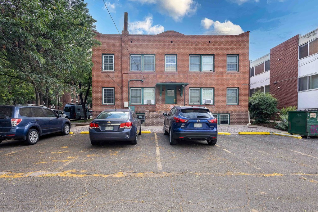 a brick building with three parking spaces in front of it
