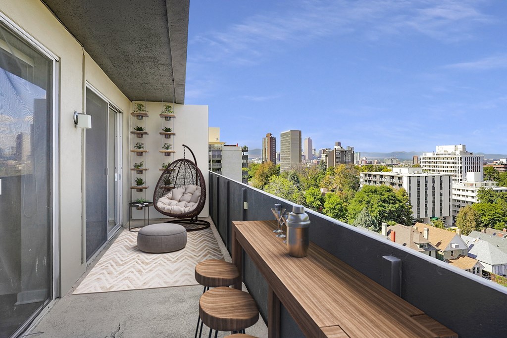 a balcony with a view of the city and a wooden table and chairs