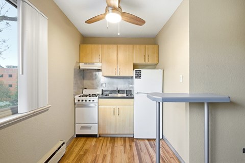 A kitchen with a white fridge, stove and wooden cabinets.