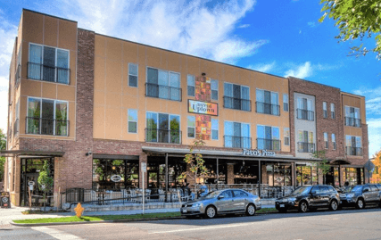 A building with a sign that says "Up Up and Away" is shown with cars parked in front.