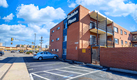 a car parked in a parking lot in front of an apartment building