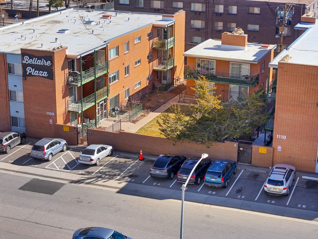 an aerial view of a parking lot with cars in front of a building