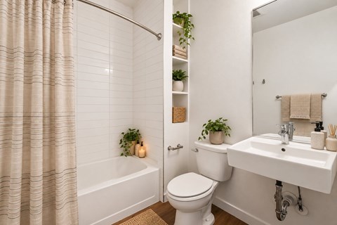 A white bathroom with a toilet, sink, and shower.