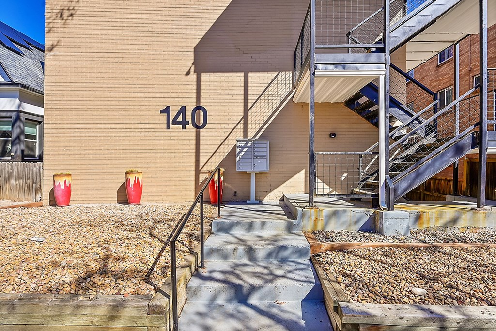 a building with stairs and a sign on the side of it