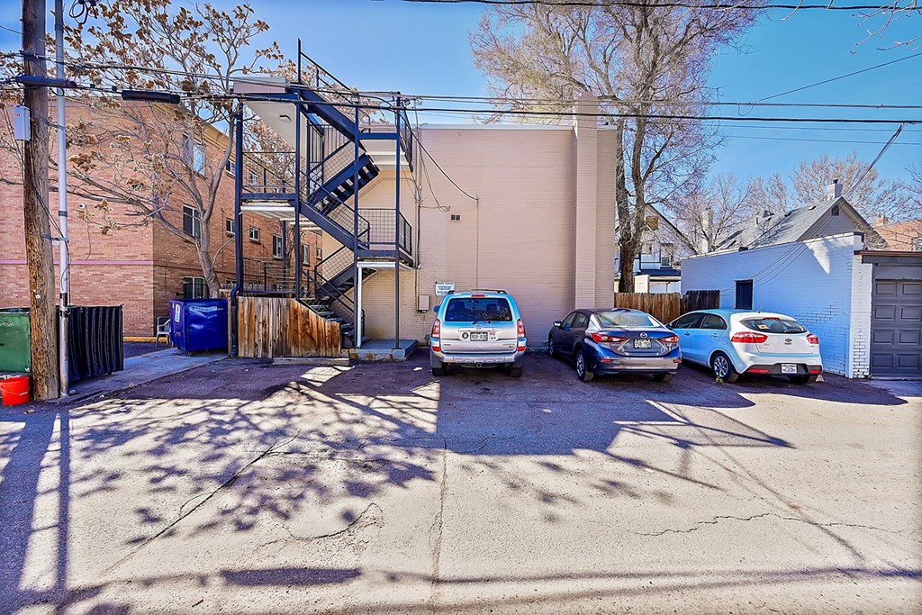 a parking lot with three cars in front of a building