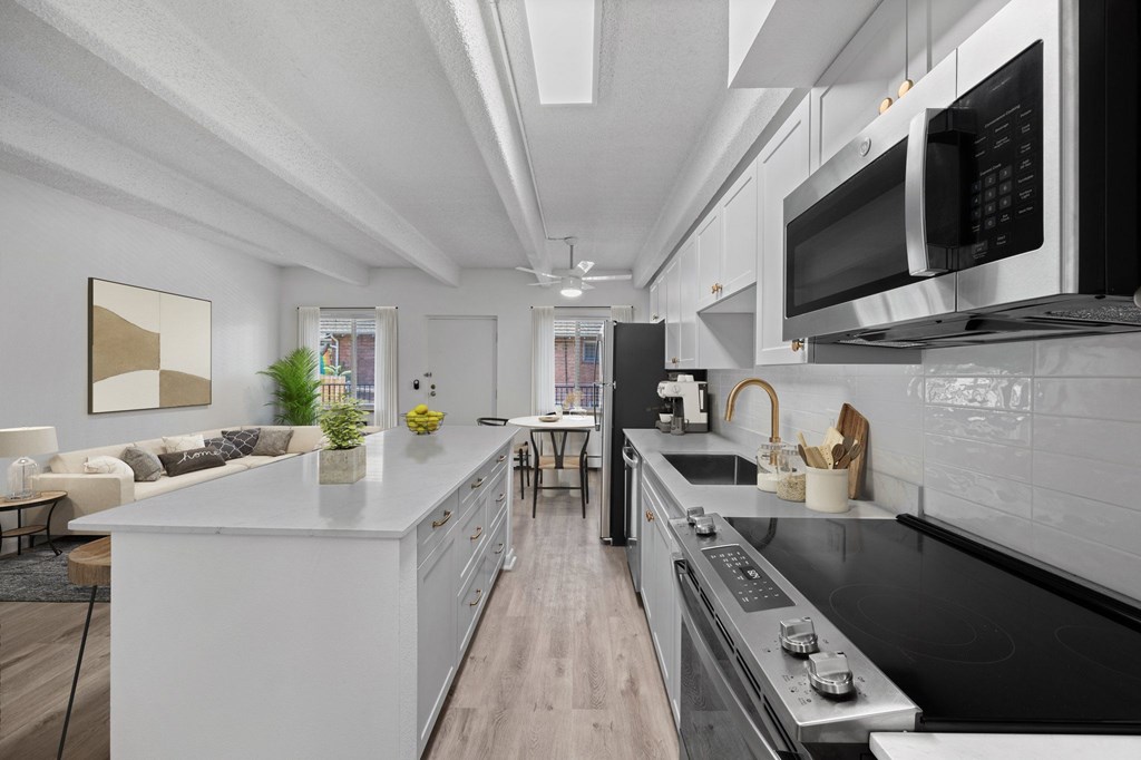 A modern kitchen with a white island and stainless steel appliances.