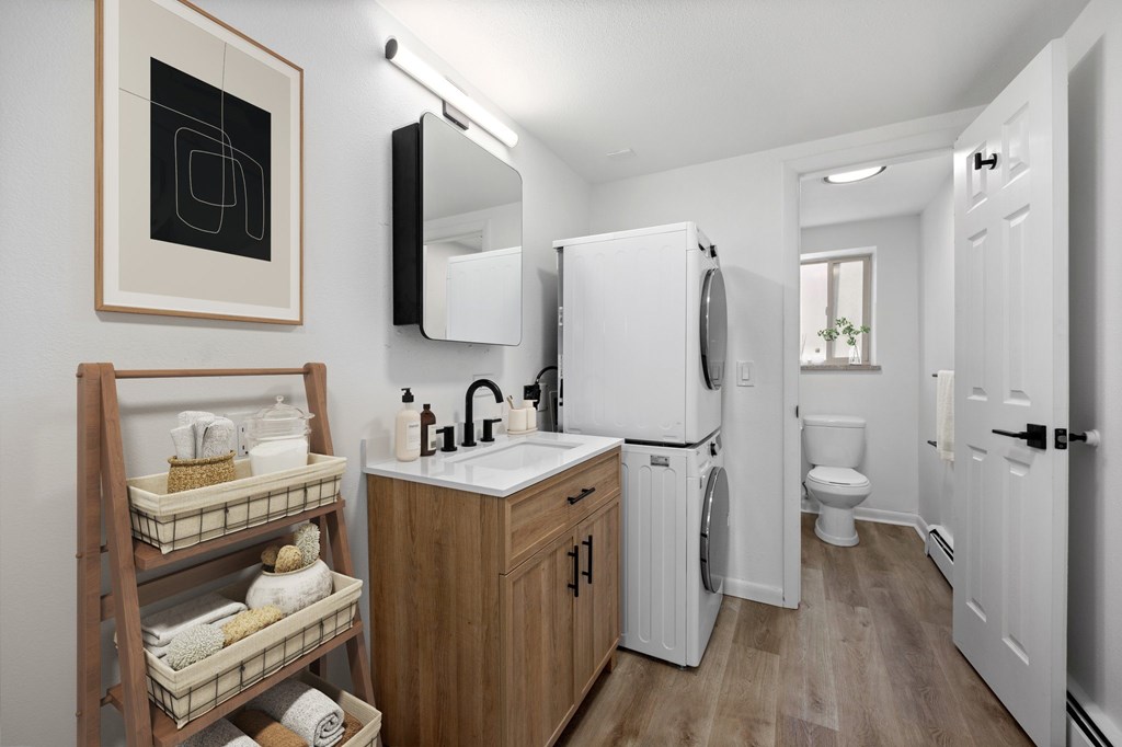 A bathroom with a white fridge and wooden cabinets.