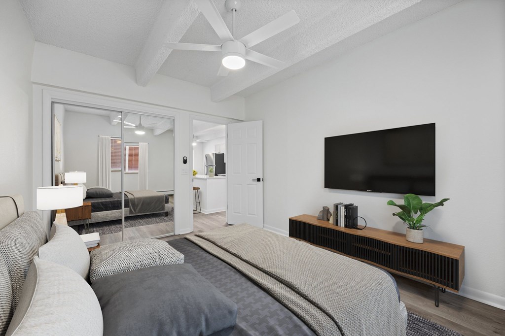 A modern bedroom with a large bed and a flat screen TV on the wall.