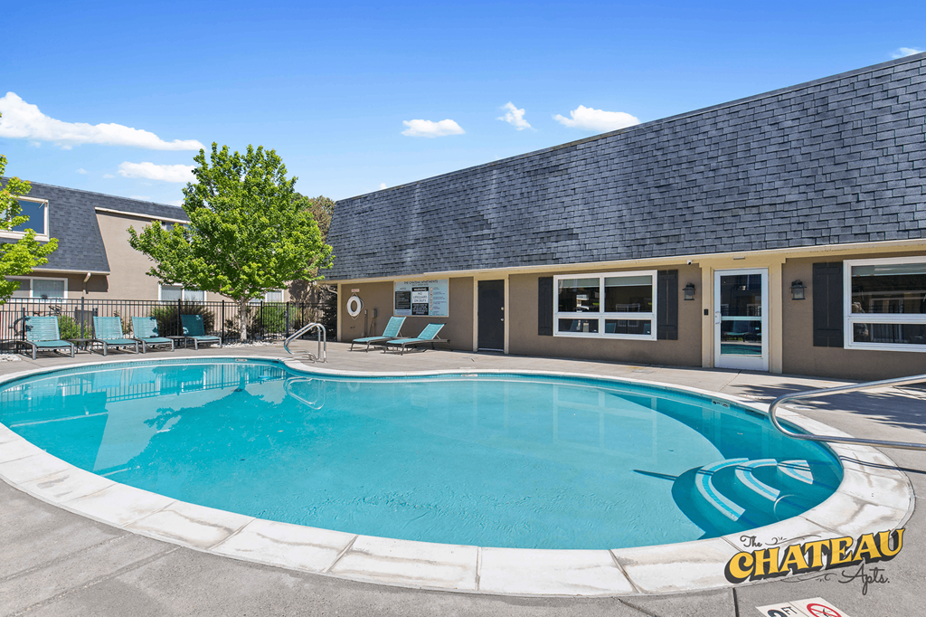 a swimming pool in front of a building with a resort style pool