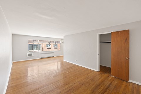 A room with a wooden floor and a door on the right side.