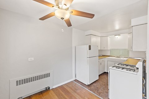 A white kitchen with a fan on the ceiling.