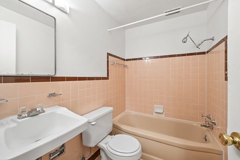 A bathroom with a sink, toilet, and bathtub.