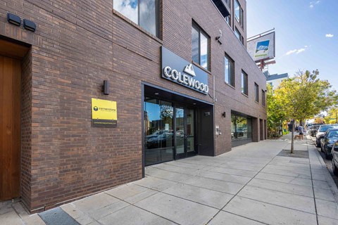 a brick building with a sign on it on the side of a sidewalk