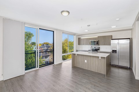 a living room with a kitchen and a balcony