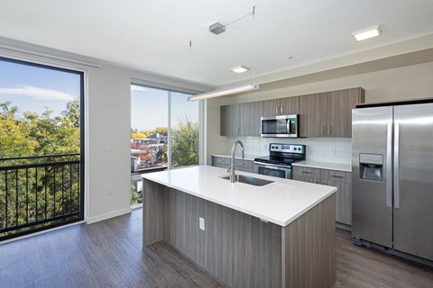 a kitchen with a large island and a stainless steel refrigerator