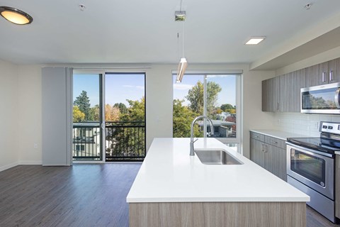 a kitchen with a white counter top and a sink