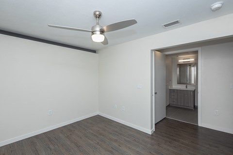 a living room with white walls and a ceiling fan