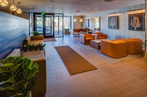 a lobby with couches and chairs and a glass door