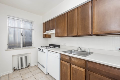 A kitchen with white appliances and brown cabinets.