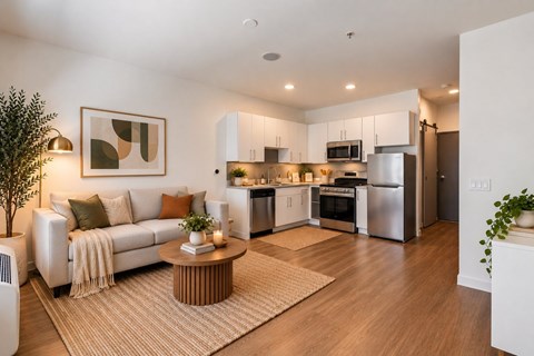A modern living room with a white couch and a coffee table in the center.