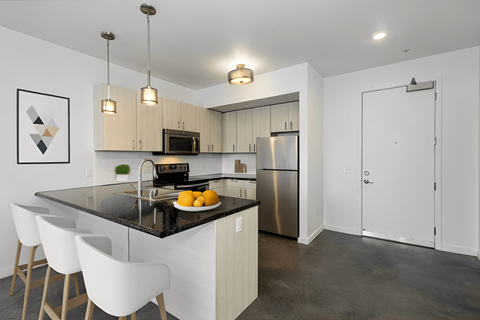 a kitchen with white cabinets and a black counter top