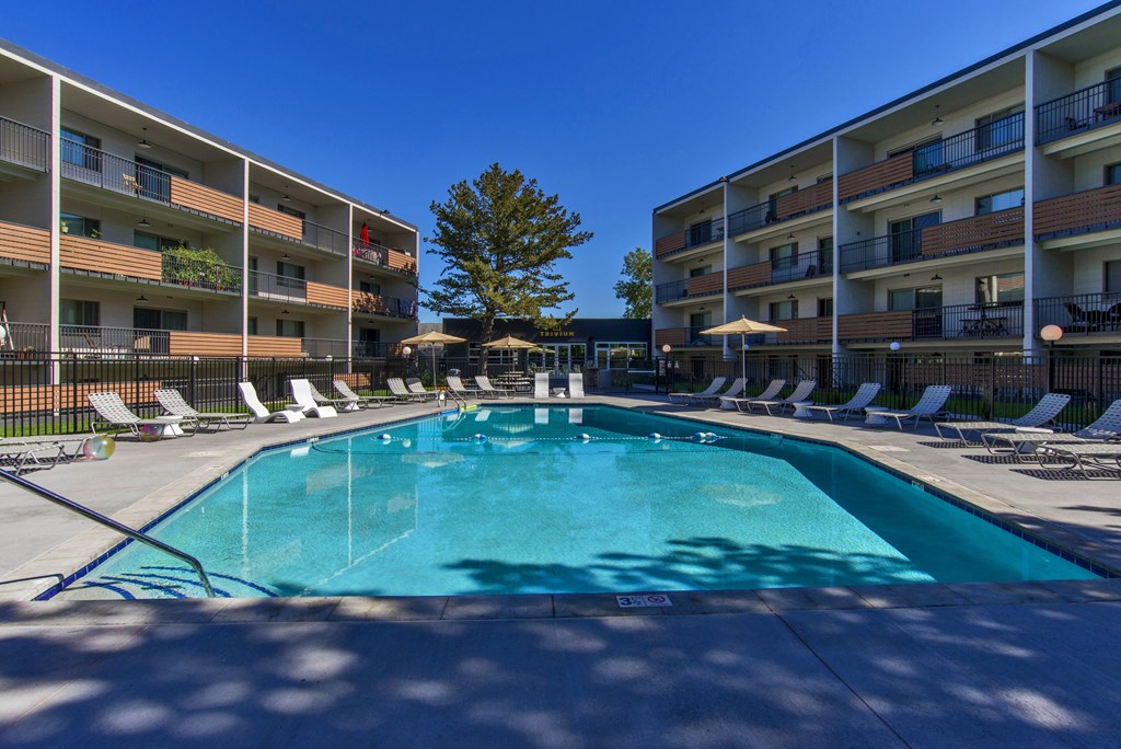 A swimming pool in front of apartment buildings.