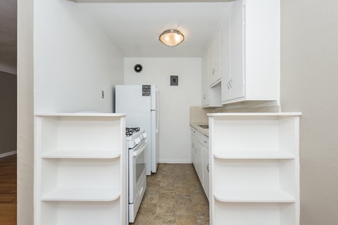 A kitchen with white appliances and cabinets.