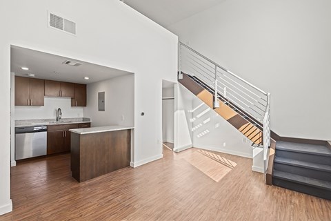 A kitchen with a refrigerator, sink, and cabinets is shown.