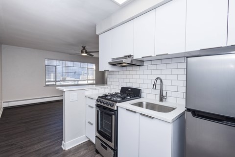 A kitchen with white cabinets and a black stove top oven.