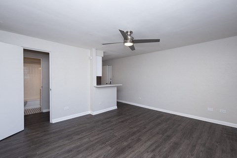 A room with a ceiling fan and wooden flooring.