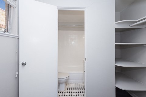 A white bathroom with a toilet and a walk in shower.