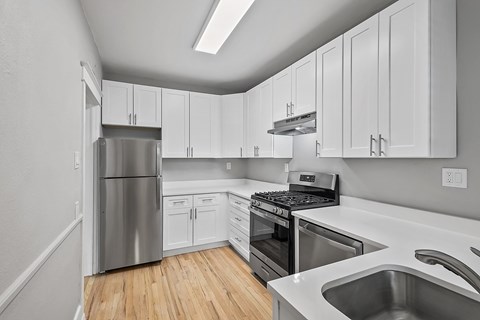 A kitchen with white cabinets and stainless steel appliances.