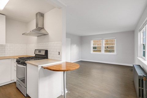 A kitchen with a stove top oven and a table.