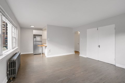 A spacious room with a kitchenette and a window.