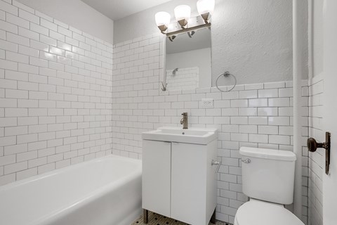 A white bathroom with a toilet, sink, and bathtub.