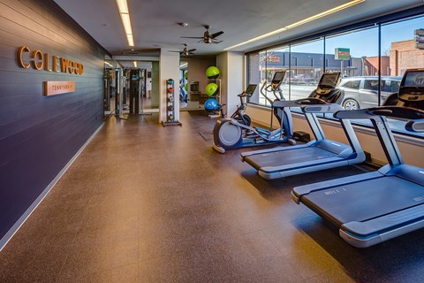 a gym with cardio equipment and a view of a parking garage