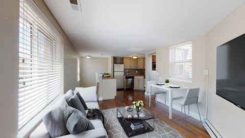 A living room with a couch, chairs, and a television.