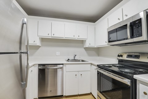 a kitchen with white cabinets and stainless steel appliances