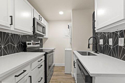 a renovated kitchen with white counter tops and black and white cabinets