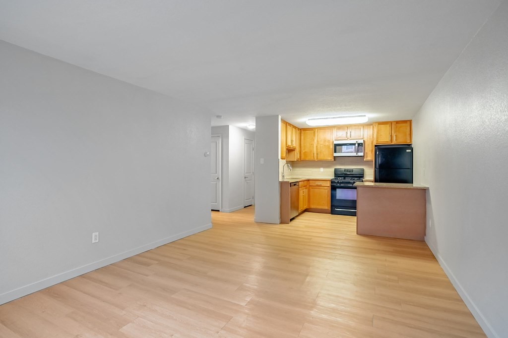 A kitchen area with a microwave, oven, and refrigerator.