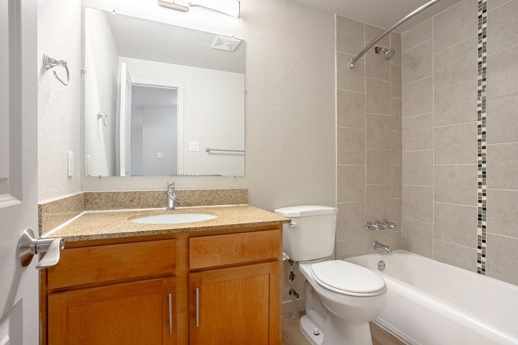 A bathroom with a toilet, sink, and bathtub.