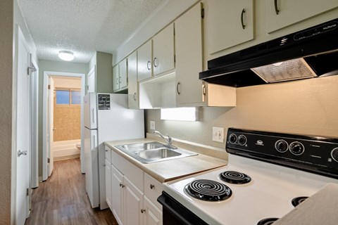 A kitchen with white cabinets and a black stove top.