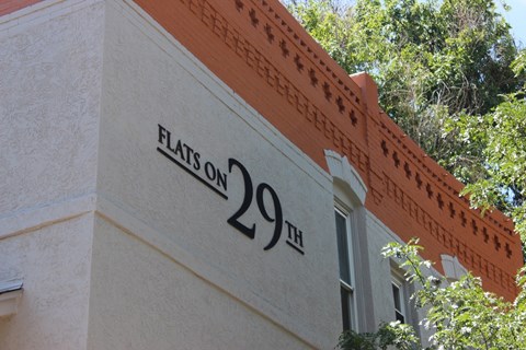 A building with a sign that says Flats on 29th.