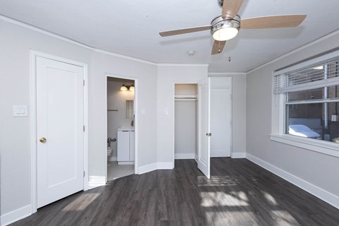 A room with a ceiling fan and wooden floors.
