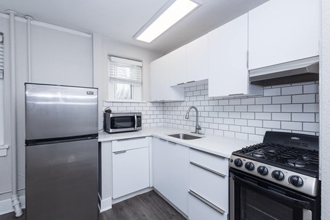 A kitchen with white cabinets and a black stove top oven.