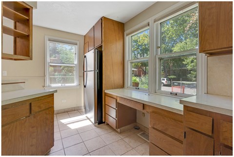 a kitchen with wooden cabinets and a large window