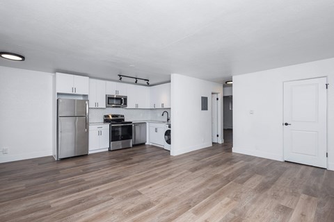 A kitchen with a refrigerator, oven, and microwave.