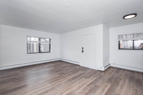 A room with wooden flooring and white walls.