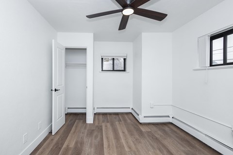 A room with a ceiling fan and a window.