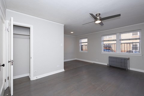 A room with a ceiling fan and a radiator on the floor.